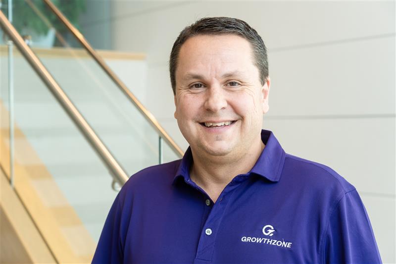 Headshot of white man with brown eyes and close-cut brown hir in a purple GrowthZone polo